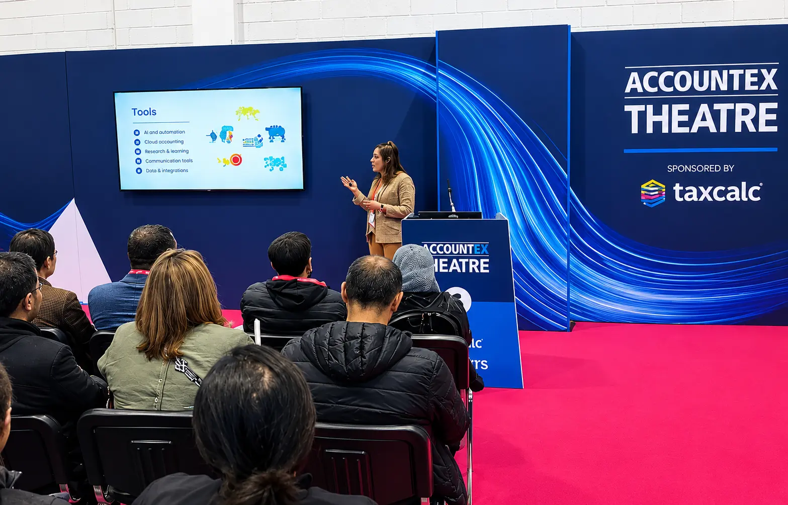 A speaker presenting to a seated audience in the Accountex Theatre.