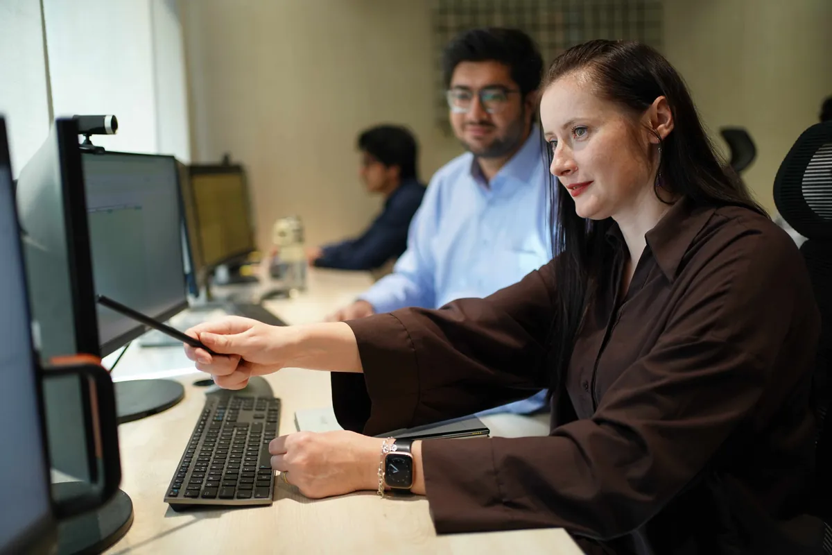 An accountant talking a colleague through figures on screen